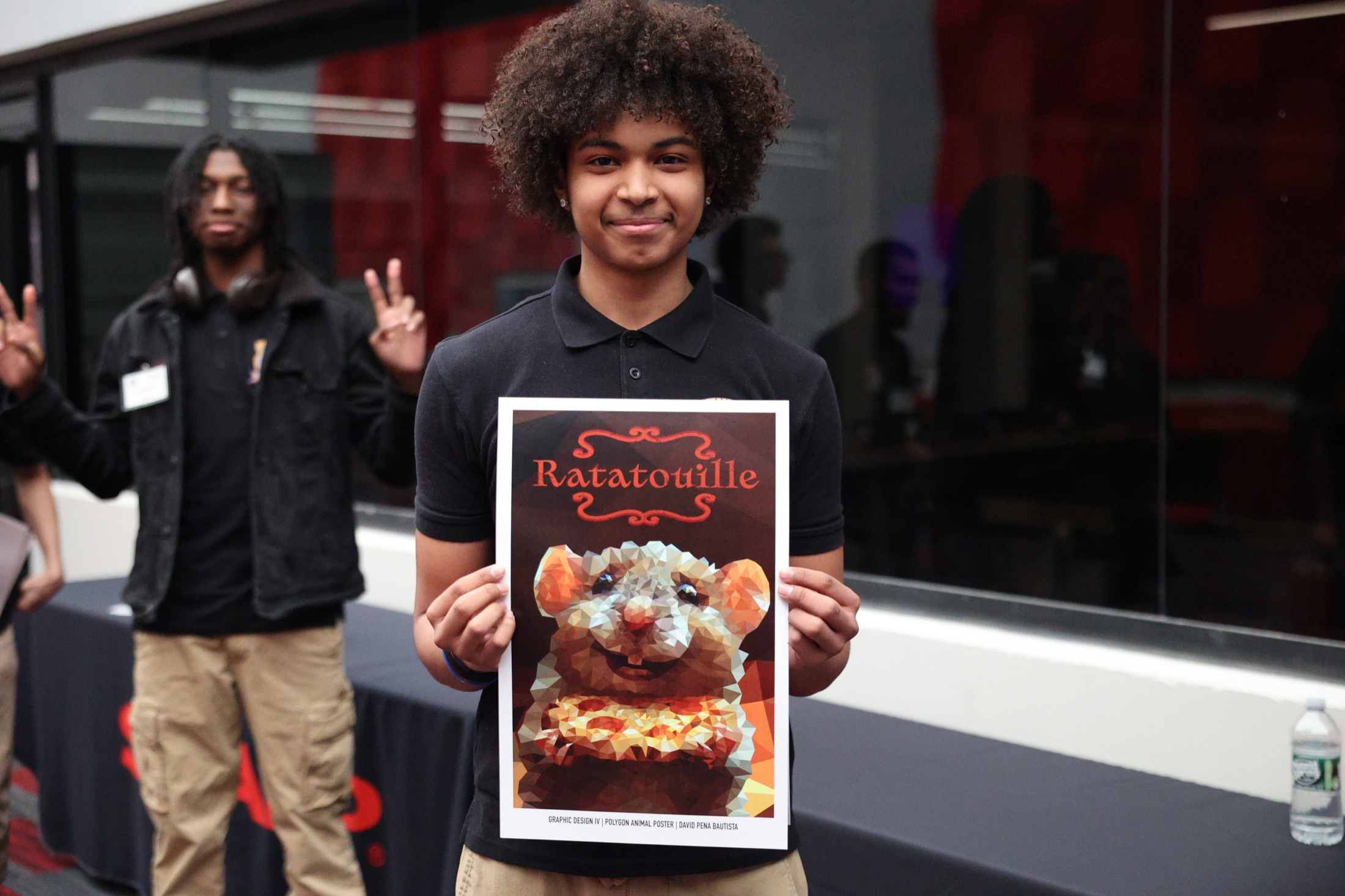 Student holding a finished Ratatouille design poster